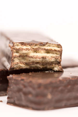 Chocolate wafers stacked over white background with copy space