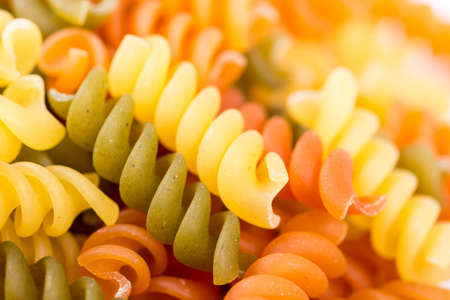 Raw colored macaroni isolated over white backgroundの写真素材