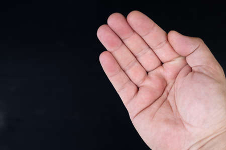 Empty male palm of the hand with black background and copy space.