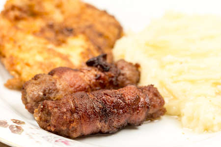 Grilled kebabs with bacon and pork steak with mashed potatoes.の写真素材