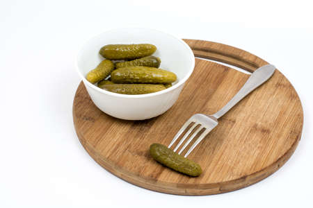 Pickles in the bowl and pickle on the fork.