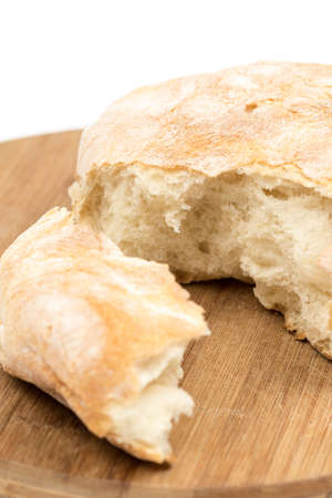 Round domestic bread sliced on the wooden board.