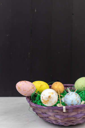 Easter Eggs in the basket with copy space on the black boards background.
