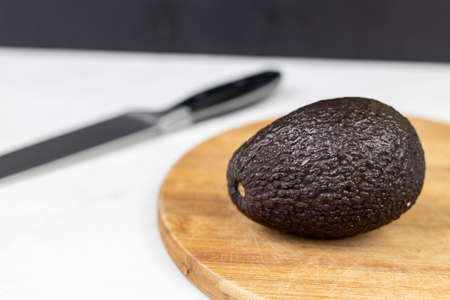 Avocado on the wooden cutting board with white background.