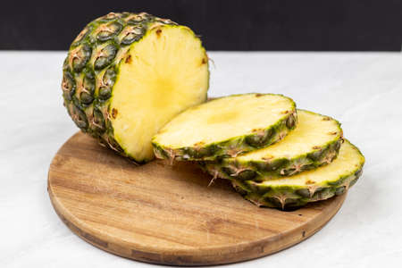 Sliced fresh pineapple served on the wooden board.