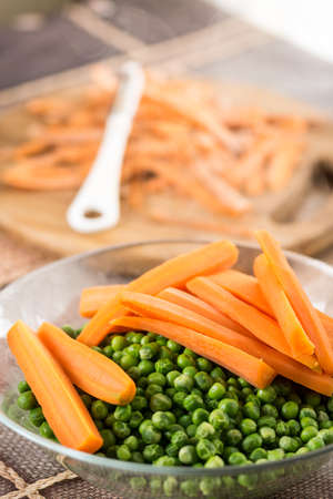 Cooked green peas with carrot in the bowl.の写真素材