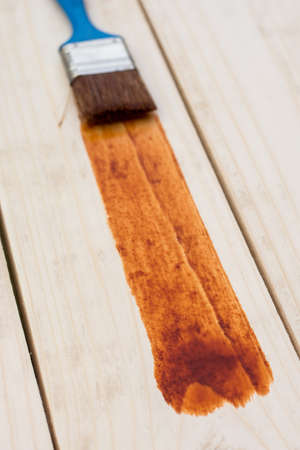 Paint brush on the painted wooden plunks board.の写真素材