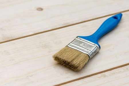 Blue paintbrush on the wooden boards table.の写真素材