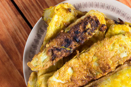 Flat lay fried zucchini in flour and eggs over wooden background.
