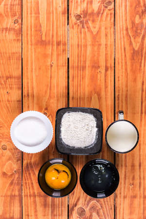 Flat lay above sugar flour egg white yolk and milk. Ingredients for american pancakes recipe.の写真素材