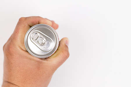 Top view of metal can in the hand for drink with copy space above white background.の写真素材