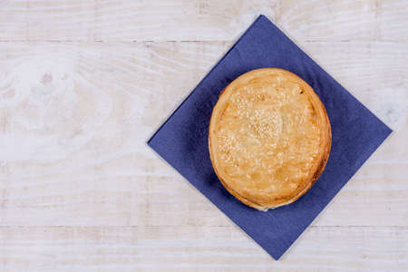Round puff pastry with sesame on the napkin over wooden background.の写真素材