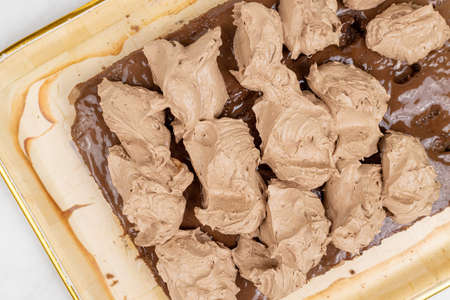 Chocolate cream on the cake. Preparing chocolate cake.