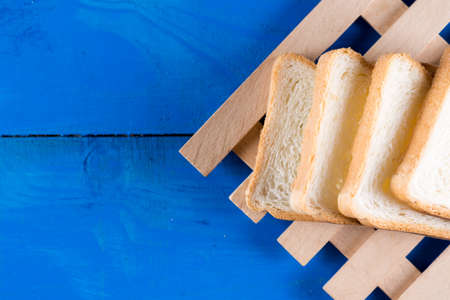 Toast bread slices on the blue wooden planks board.
