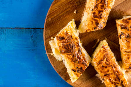 Closeup macro flat lay domestic cheese pie slices served on the round board.の写真素材