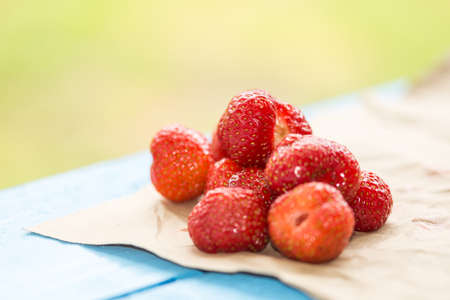 Strawberries on the wrinkled brown paper background.