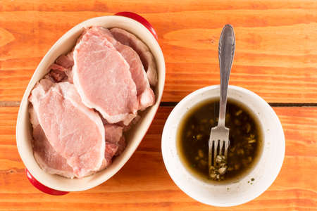 Raw pork chops with barbecue marinade flat lay top viewの写真素材