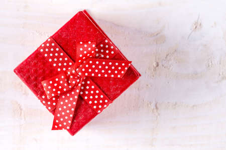Flat lay box with bow above wooden background planks.の写真素材