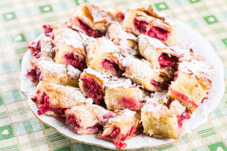 Cherry cake with powdered sugar on the plate.