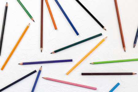 Old colored wooden pencils on the white board background.