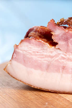 Raw homemade pork bacon on the round wooden board.の写真素材