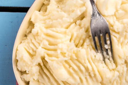 Flat lay mashed potatoes in the bowl on the wooden planks table.の写真素材