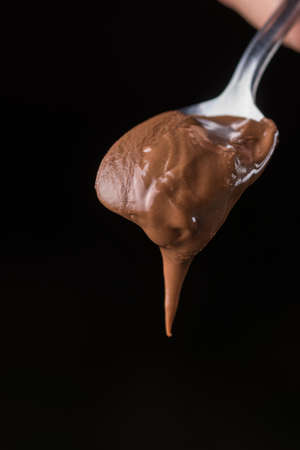 Chocolate nougat creme with spoon on the table.