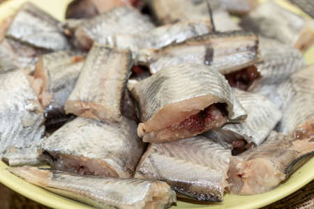 Selective focus on sliced hake fish on the plate.