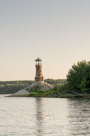 Old brick lighthouse on the river with clear sky.の写真素材