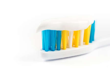 Closeup macro toothpaste on toothbrush isolated over white background.の写真素材