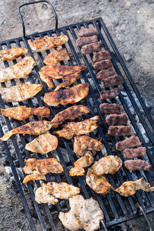 Flat lay above chicken white breast meat on the barbecue grill with kebabs.