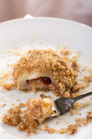 Closeup macro of plum dumplings on the plate with metal fork.
