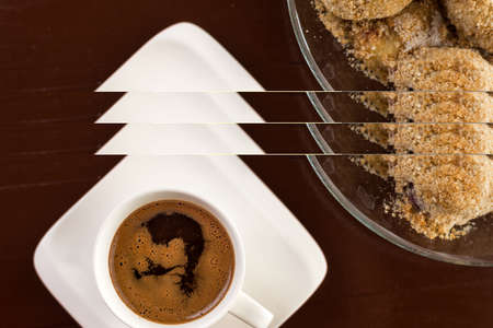 Flat lay above white cup of coffee with plum dumplings on the brown wooden table.
