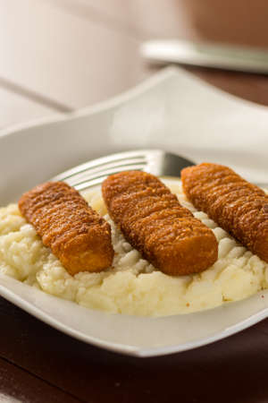 Flat lay above plate served with fish sticks and mashed potatoes.の写真素材