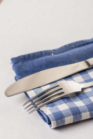 Silverware metal knife and fork on the blue kitchen dishtowel.