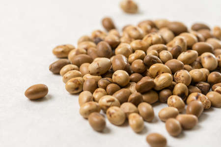 Closeup macro of soya beans on the white marble background.
