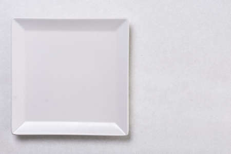 Flat lay above white square plate on the white marble background table.の写真素材