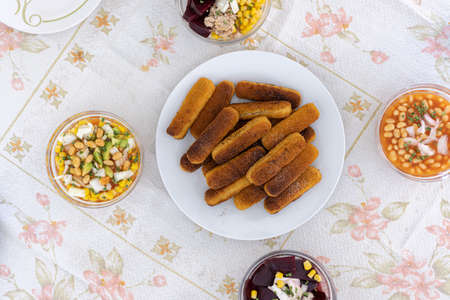 Fish sticks served with salads of beans corn avocado onions and beet.の写真素材