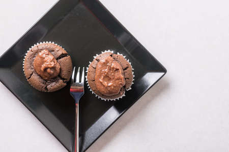 Flat lay above chocolate cup cake muffin on the black square plate.の写真素材