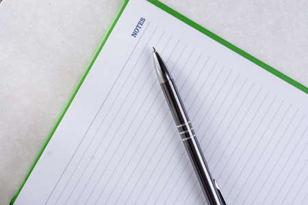 Flat lay above business notes with pen on the white marble.