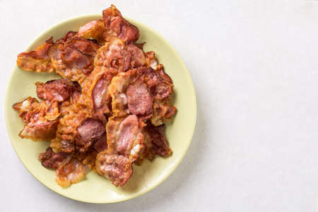 Crisp fried bacon on the plate above white marble background table.の写真素材