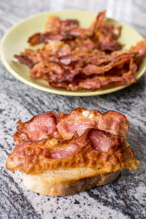 Crisp fried bacon on the bread above grey granite background.の写真素材
