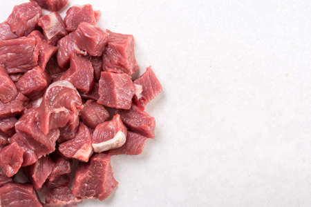 Flat lay above chopped raw beef steak on the white marble background with copy space.の写真素材