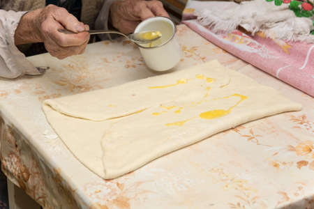Grandmother making puff pastry on the table.の写真素材