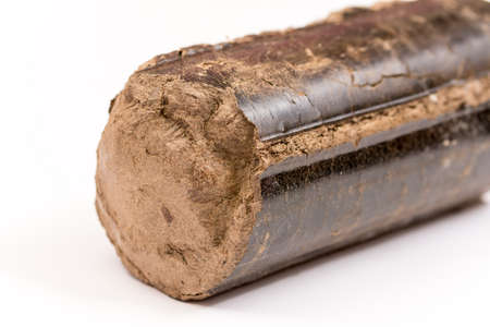 Brown pressed wood briquettes over white background.