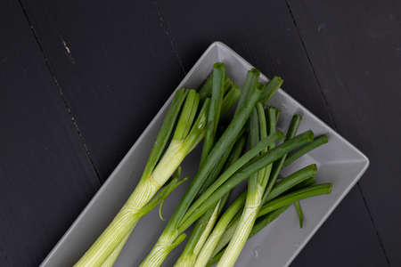 Top view of fresh young onions on the plate.の写真素材