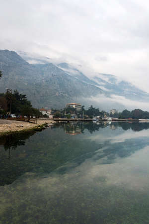 Foggy weater on the sea with mountain reflections.の写真素材