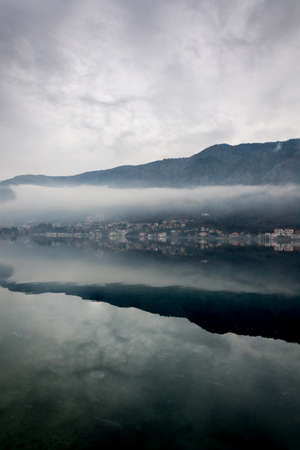 Foggy weater on the sea with mountain reflections.