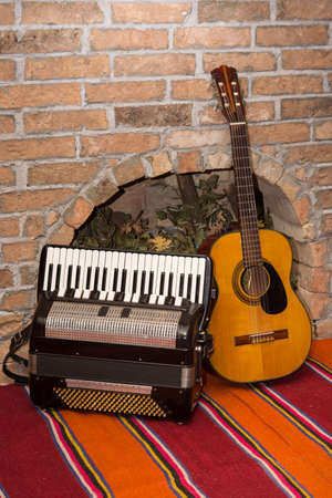 Accoustic guitar on the brick wall and accordion.の写真素材