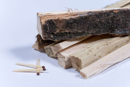 Wooden matches with stacked firewood over white background.の写真素材